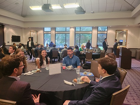 Alumni and current students gathered around tables for discussion