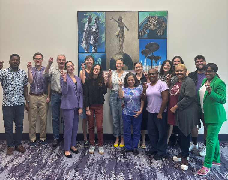 Faculty members at the New Faculty Mentorship Program 2025-2026 academic year kickoff event. They are holding up the Go Frogs hand sign.